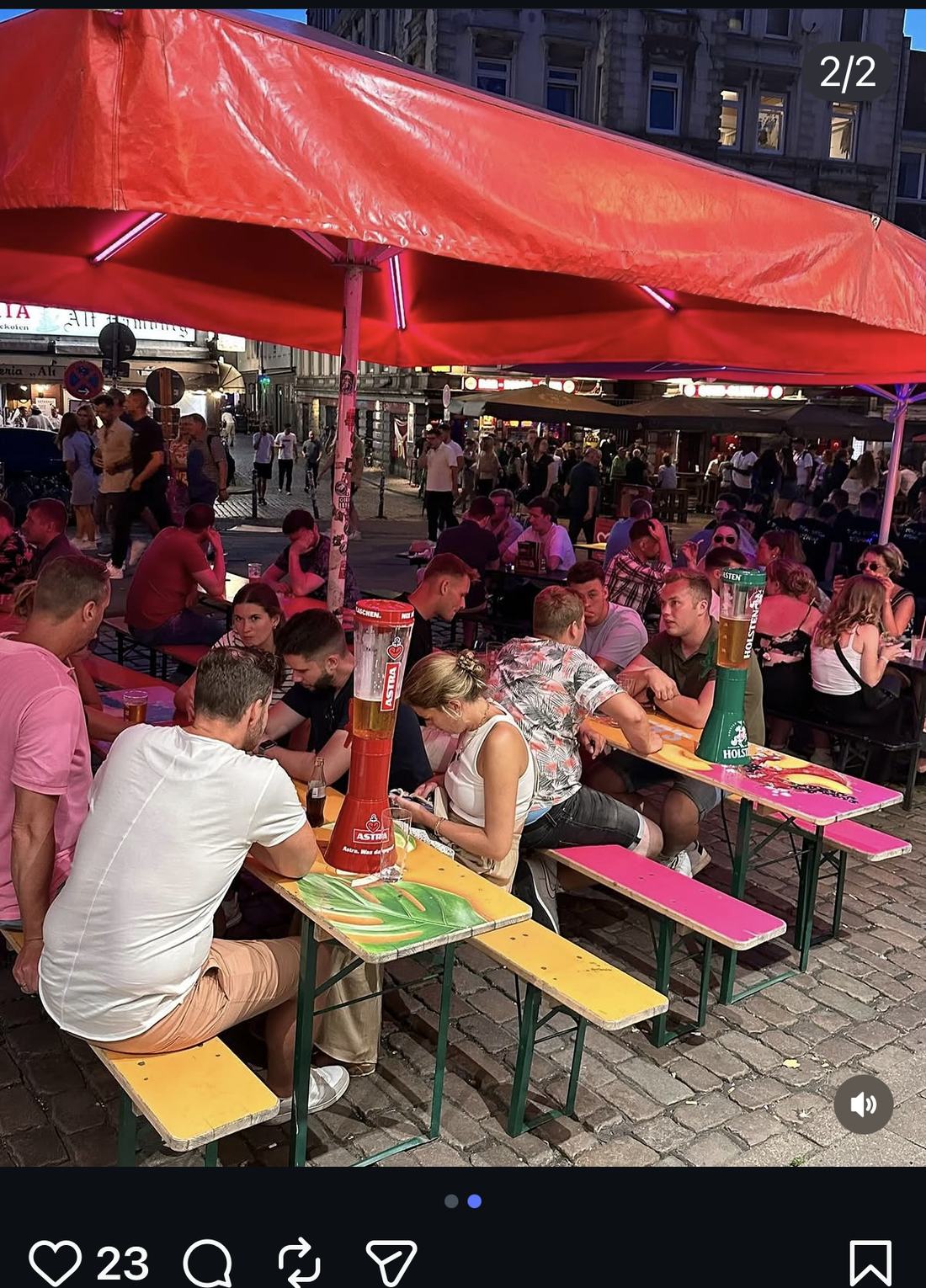 Gäste unter dem roten Sonnensegel der London-Pub-Terrasse am Hans-Albers-Platz