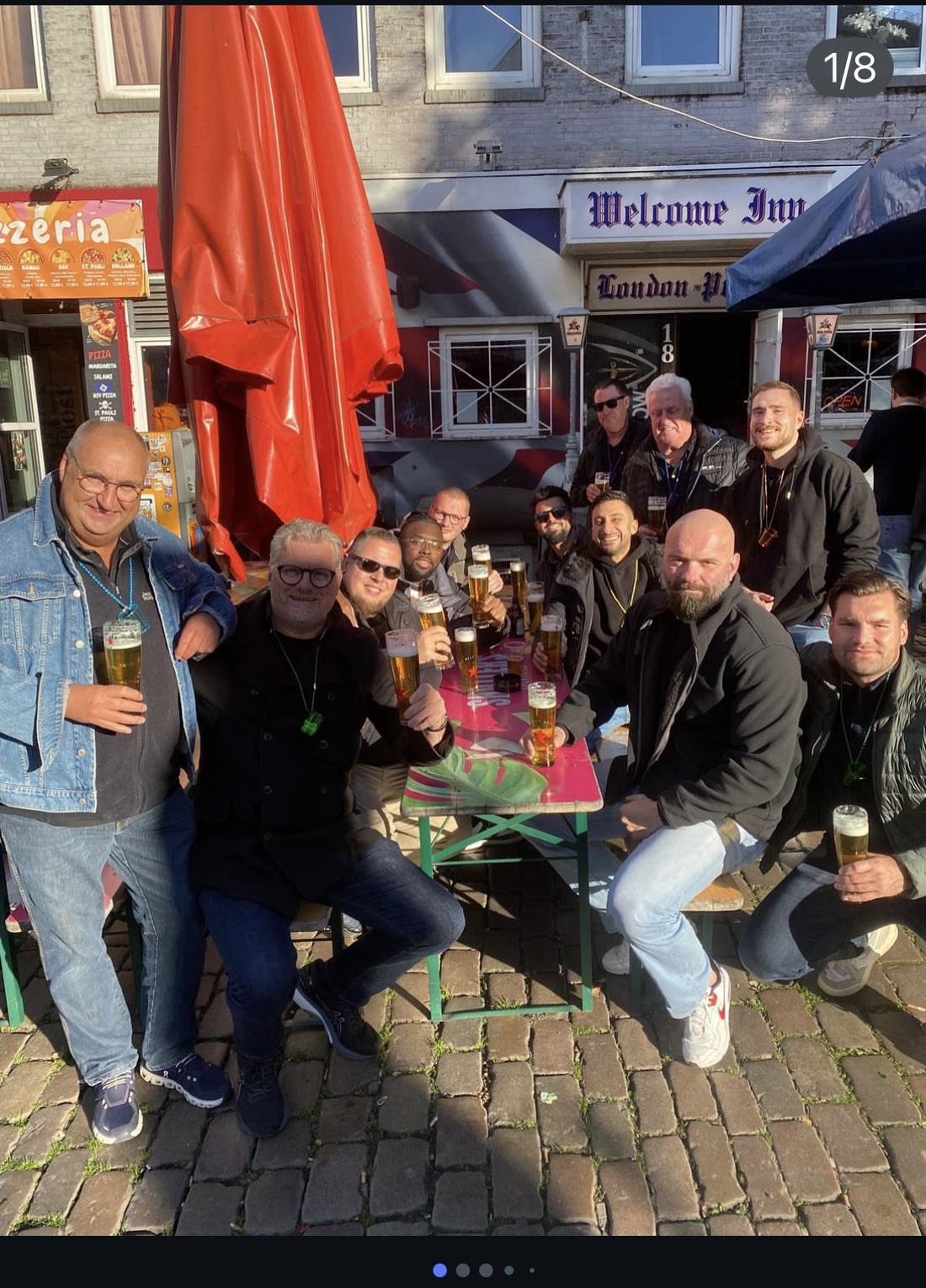 Anstoßen auf der Terrasse vor dem Schriftzug London Pub